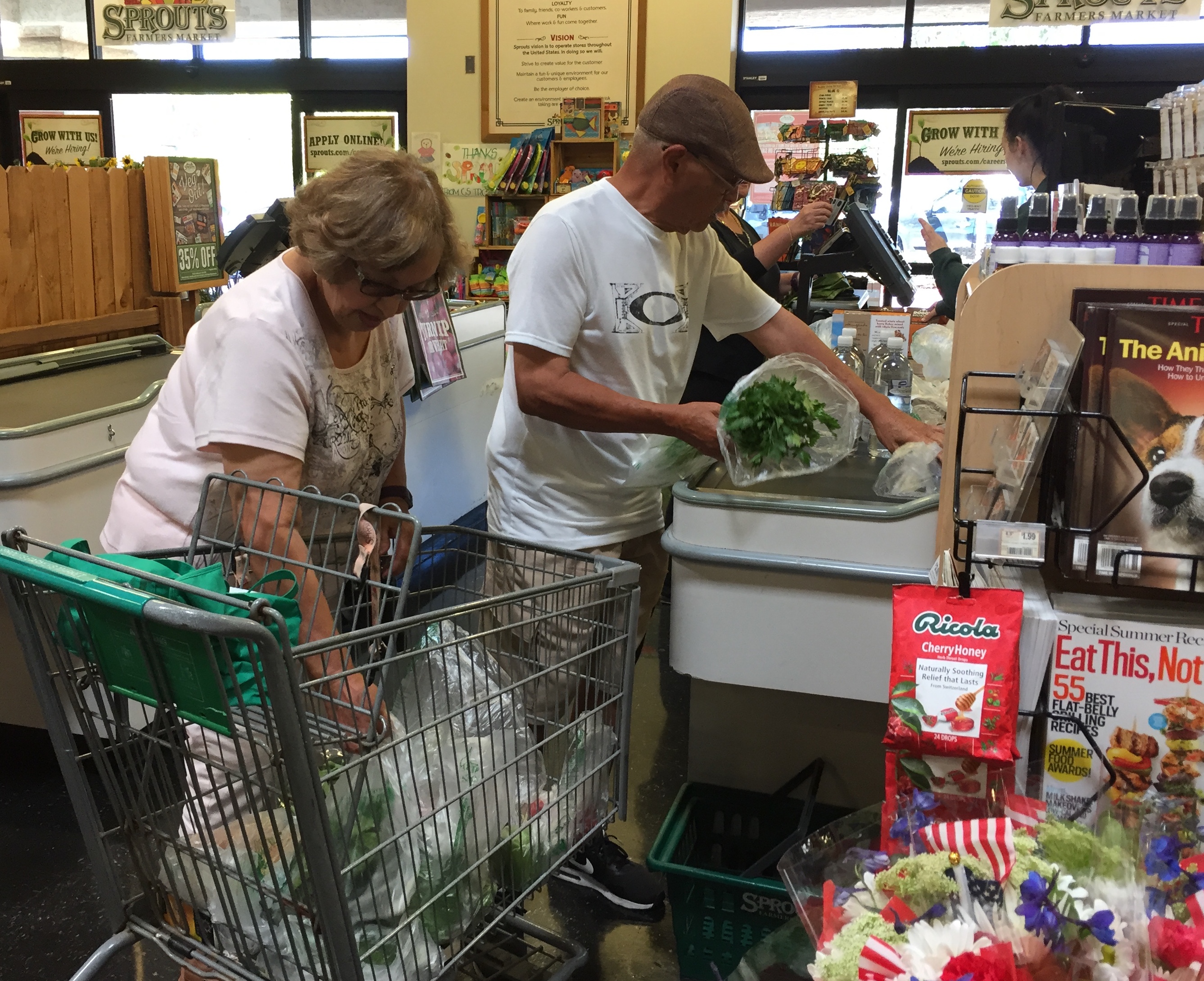 Teri and Oscar Lara load their healthier grocery items at the Sprouts checkout. Both have lost weight since they began watching what they eat. June 27, 2017. Cheryl Clark, inewsource