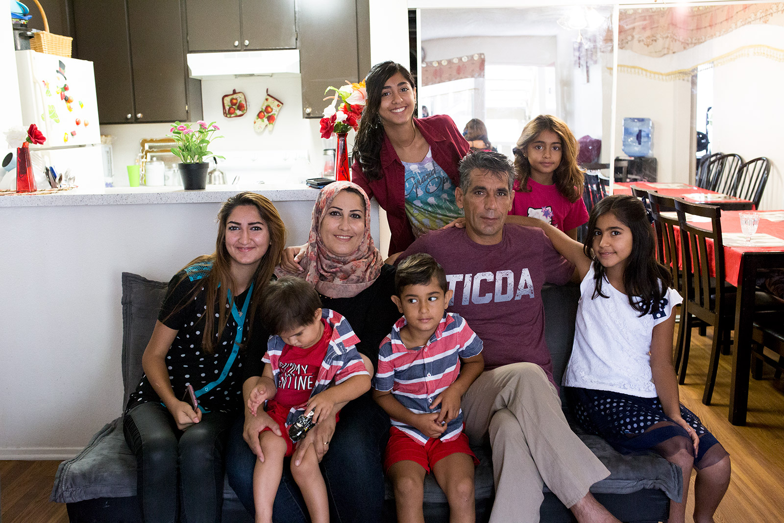 Daliya Ail, center, and her husband, Salim Musa, pose with their six children in their two-bedroom El Cajon apartment, July 25, 2017. Photo by Megan Wood, inewsource.